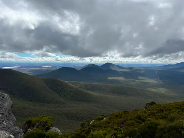 Green ranges and valleys under a cloudy sky