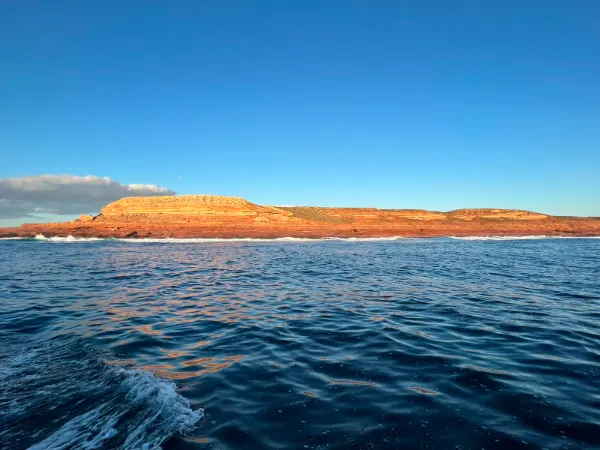 Red cliffs above deep blue water